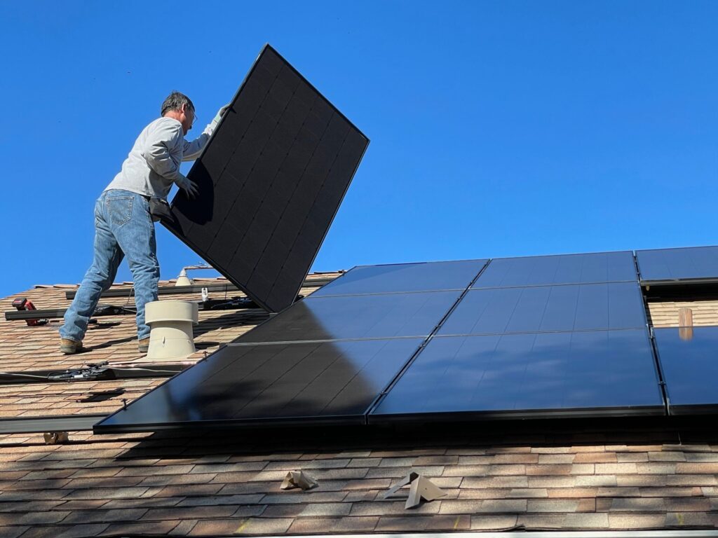 A worker installing IBC solar panels on a rooftop (Four major changes in 2022 could have profound impact on the solar industry)