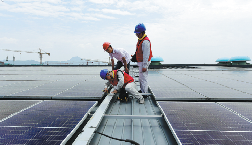 Workers installing solar panels on the rooftop